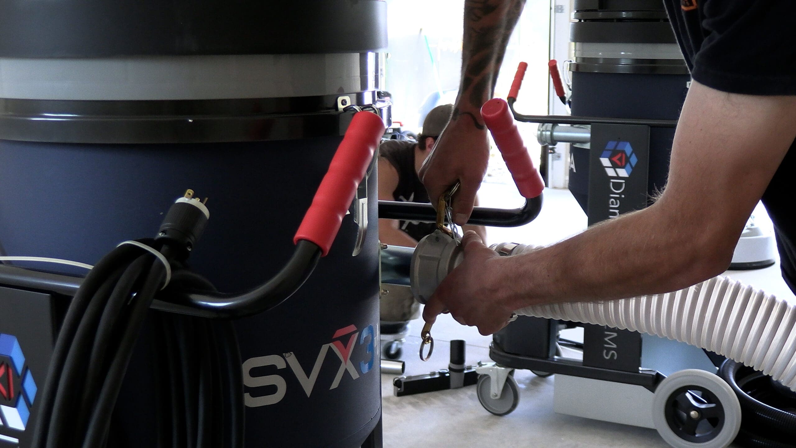 Black Mountain Epoxy Floors crew assembling concrete grinding equipment for an epoxy floor project.